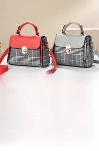 Detailed shot of houndstooth crossbody bag with golden twist lock and bicolor flap design