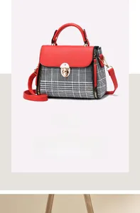 Detail of red leather and plaid patchwork handbag with gold metal clasp and strap