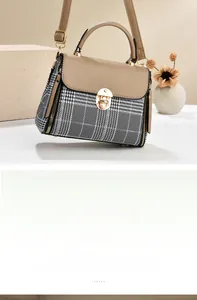 Detail of classic plaid crossbody handbag with gold twist lock and slim shoulder strap