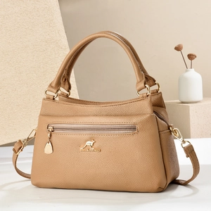 Detailansicht der Handtasche aus Leder mit Litschistruktur, Gold-Logo und Reißverschluss