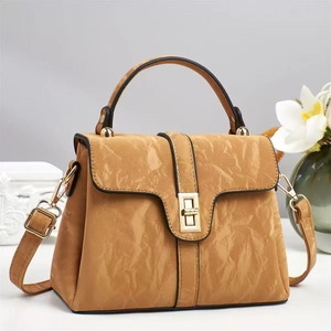 Close-up of mustard yellow handbag with marble texture leather and golden turn lock