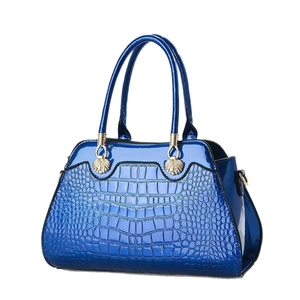 Royal blue crocodile embossed leather handbag with gold accents and dual handles