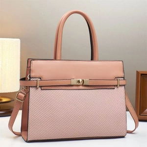 Elegant textured pink tote bag with latch closure and crossbody strap in a modern setting