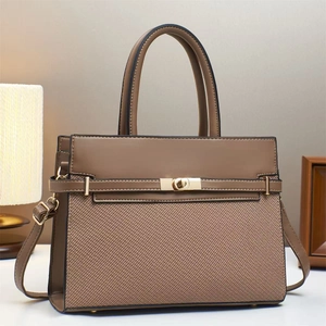 Close-up of brown textured leather handbag with gold twist lock and protective metal feet