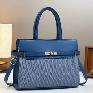 Detailed view of the navy blue leather and woven fabric tote with a gold twist-lock closure