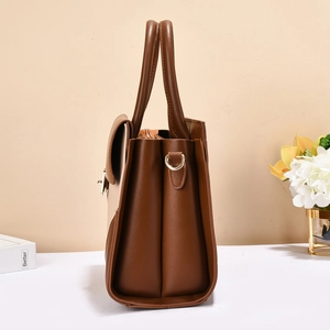 Detailed side view of brown patchwork handbag showing accordion structure and metal hardware