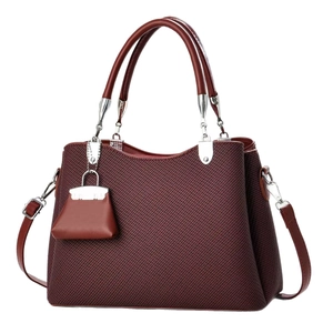 Minimalist burgundy textured handbag with top handles and adjustable shoulder strap