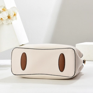 Macro view of cream lychee texture leather bag base with brown anti-wear patches