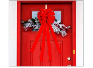 Large red velvet Christmas bow with gold trim and snow-dusted pine branches for doors