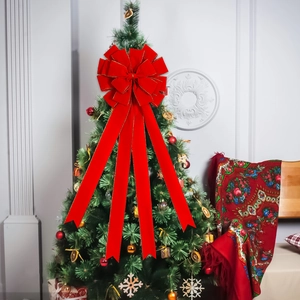 Large red velvet Christmas bow with gold trim on a decorated holiday tree topper