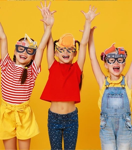 Kinder mit Cartoon-Bagger-Partybrillen als lustige Requisiten für Geburtstagsfotos