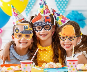 Detailaufnahme von Kindern mit Bagger-Partybrillen und Dekoration zum Kindergeburtstag