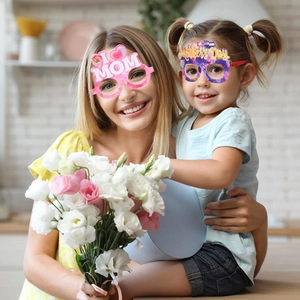 Close-up of mother and child wearing Happy Mother's Day paper party glasses with heart motifs