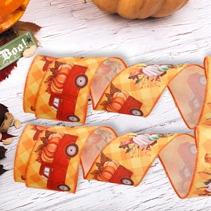 Detail of faux linen Halloween ribbon with pumpkin truck pattern and orange wired edges