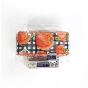 Close-up of Halloween ribbon roll with pumpkin pattern weighing 63.8g on a digital scale