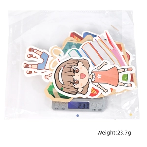Cartoon girl stickers in packaging being weighed on scale, showing total weight of 23.7g
