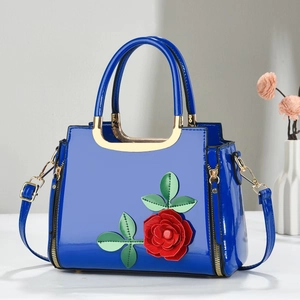 Blue patent leather handbag with red flower appliques and gold metal handle accent