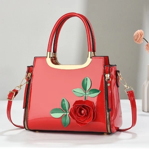 Red patent leather handbag with 3D rose floral appliques and gold-tone metal handles