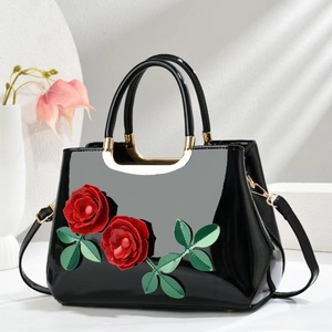 Glossy black patent leather handbag featuring 3D red roses with green leaves detail