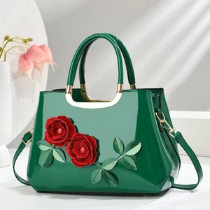 Glossy dark green patent leather handbag featuring 3D red roses and a top handle strap