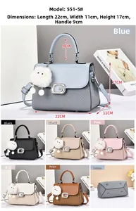 Detail of small square handbag showing contrast textures, G-logo buckle and pompom charm