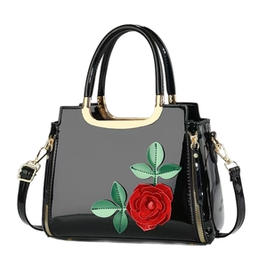 Glossy black patent leather handbag with red rose floral applique and gold metal handles