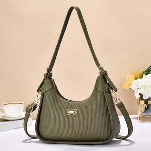 Detail of dark green underarm bag with vertical texture and golden bow buckle decoration