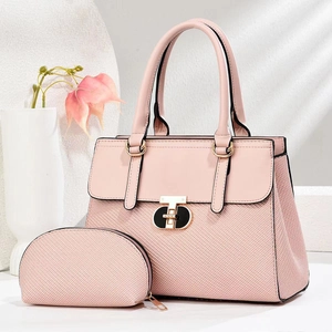 Detailed view of pink woven fabric texture and gold interlocking metal buckle on handbags