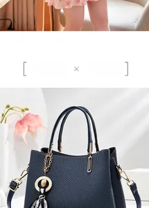 Détail du sac à main tissé bleu foncé avec ferrures dorées et foulard rayé en soie