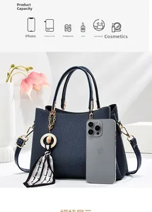 Détail du sac cabas tissé bleu foncé avec foulard décoratif et finitions en métal doré