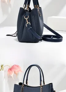 Détail montrant la texture tressée bleue en similicuir et les garnitures dorées du sac à main