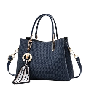 Sac à main bleu marine élégant avec motif croisé, breloque en soie et bandoulière