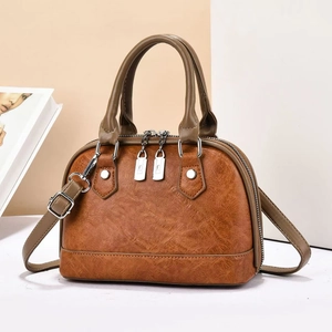 Classic brown shell handbag with olive green straps and smooth dual zipper closure