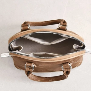 Interior view of brown retro shell bag showing herringbone lining and zipper pocket