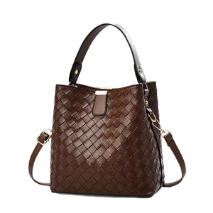 Deep brown woven bucket bag with top handle and gold hardware in minimalist style