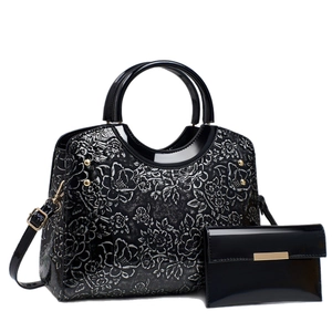 Elegant black patent leather handbag set with silver floral embossing and matching wallet