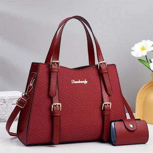 Detail of burgundy tote and coin purse set with textured surface and gold Danbaoly logo