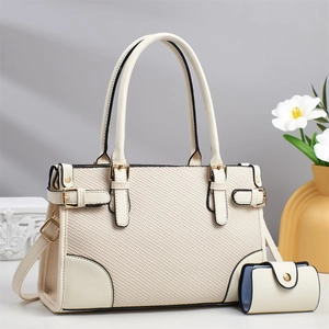 Minimalist cream textured handbag with gold hardware and shoulder strap on pedestal