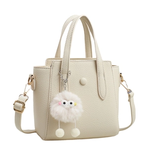 Off-white lychee texture leather tote bag with top handles and plush charm detail