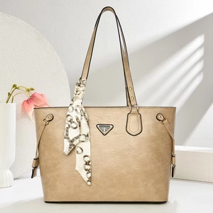Detail of champagne leather tote bag with metal logo and chain print silk scarf