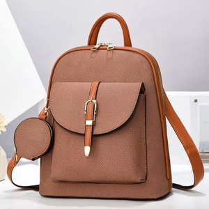 Brown canvas backpack with leather straps and round coin pouch shown in studio