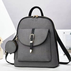 Detail of grey textured fabric backpack with gold zippers and detachable round pouch