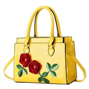 Glossy yellow patent leather handbag with 3D red floral applique and shoulder strap