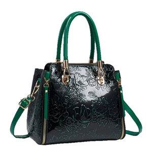 Green and black patent leather tote bag with floral embossing and gold hardware