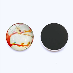 Macro view of round glass magnet showing watercolor owl design and black magnetic backing