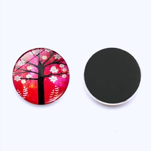 Macro shot of 25mm Tree of Life glass fridge magnet with cherry blossom pattern