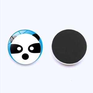 Macro detail of round glass panda fridge magnet with blue background and magnetic back