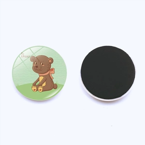Detail of 25mm round glass fridge magnet showing a cute brown bear design and magnetic back