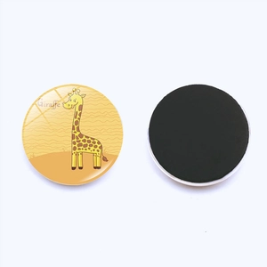 Detail of round magnetic fridge magnet featuring a cute giraffe on a yellow background