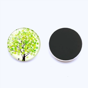 Gros plan d'un aimant de réfrigérateur rond en verre de 30mm avec motif d'arbre vert